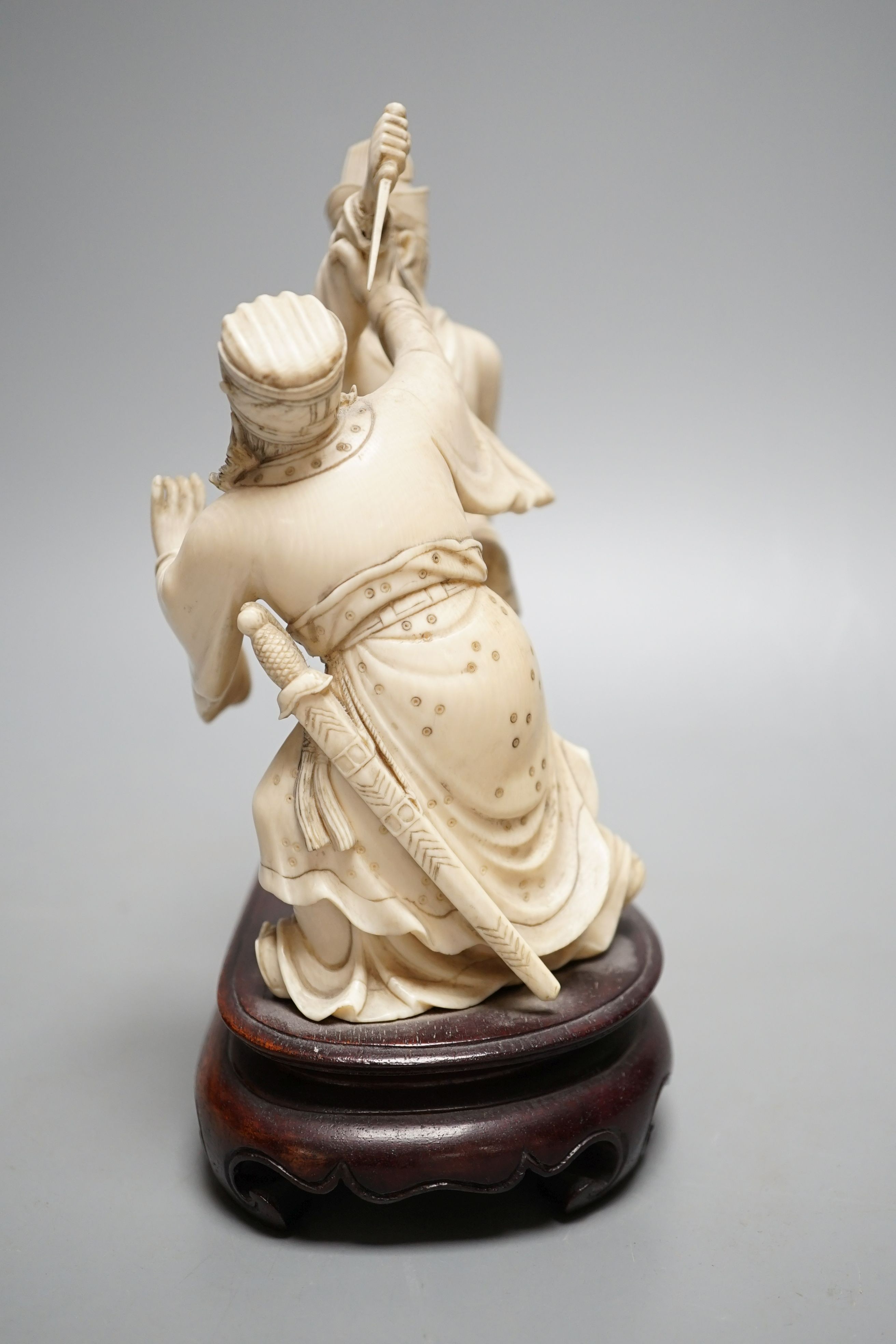 An early 20th century Chinese ivory group of two fighting officials - 21cm tall
